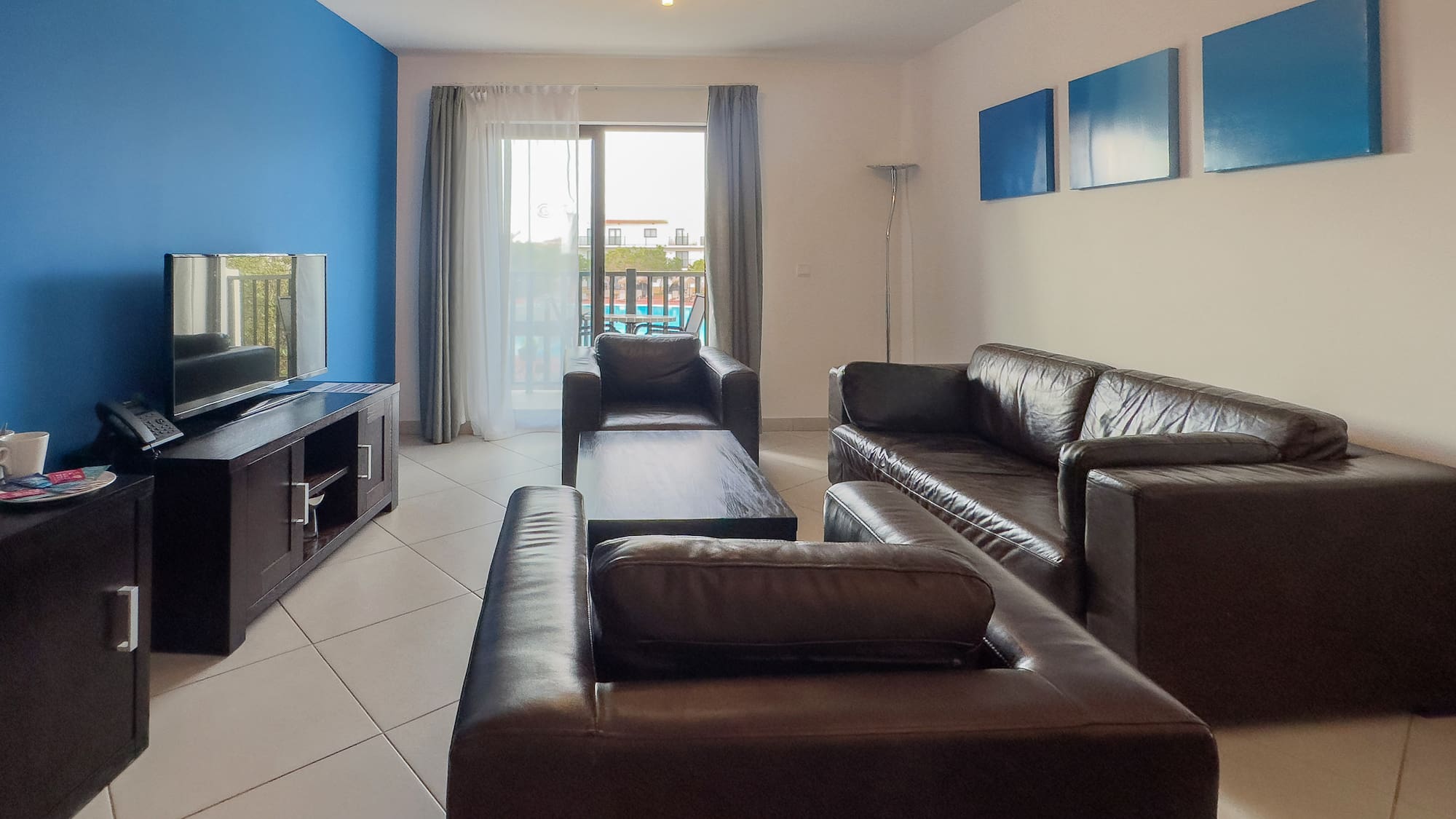 a living room with leather couches and a television