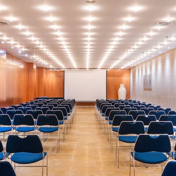 a room with rows of chairs and a projector screen