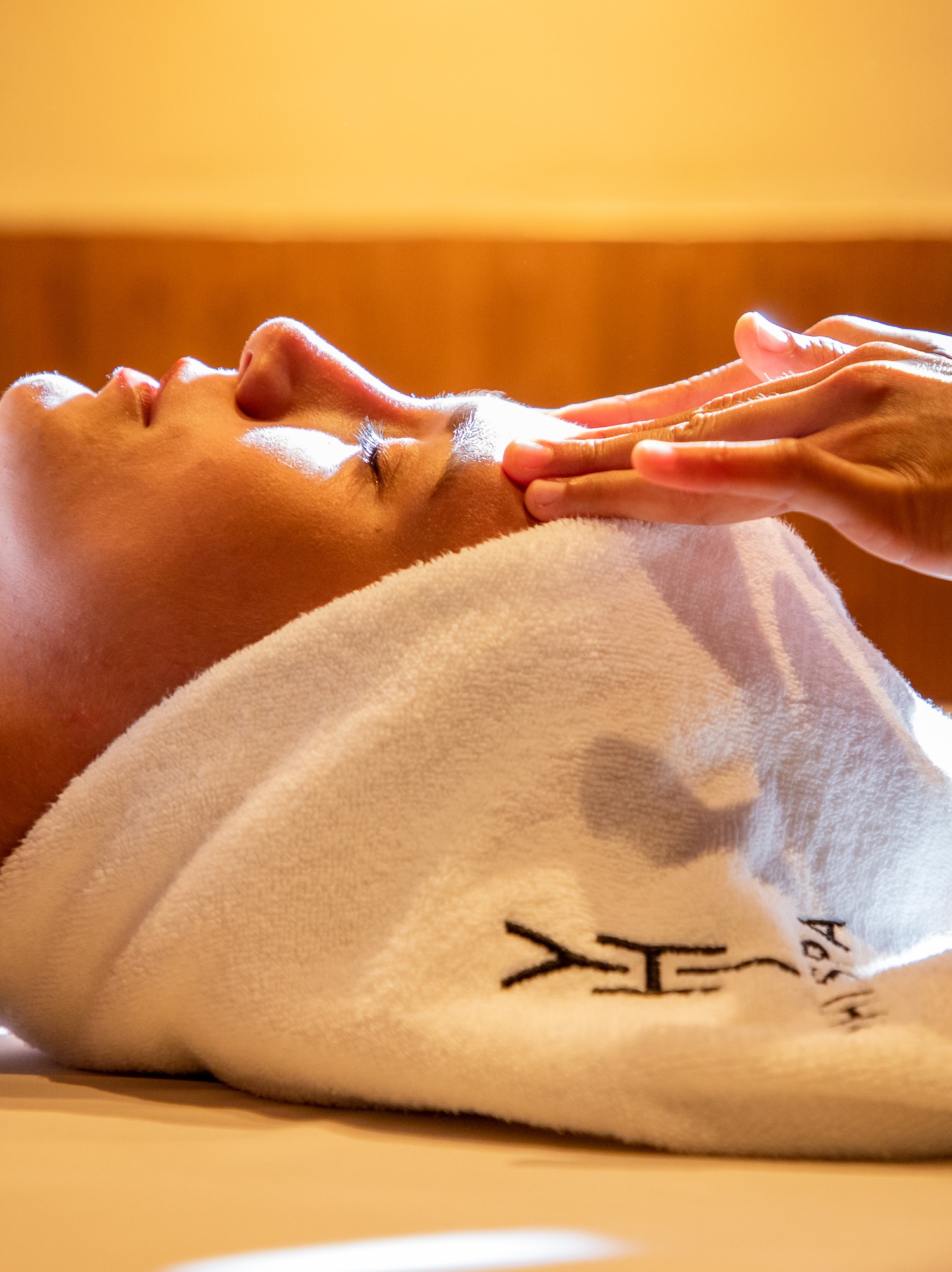 a person lying down with a towel on their head