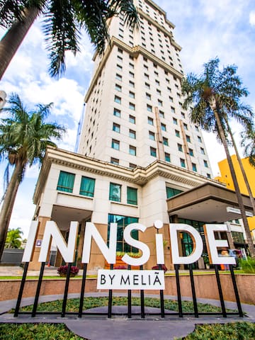 a building with palm trees and a sign