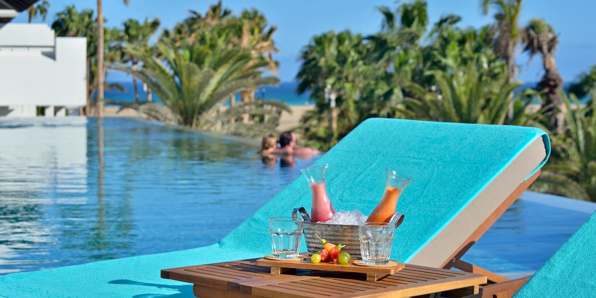 a table with drinks on it by a pool