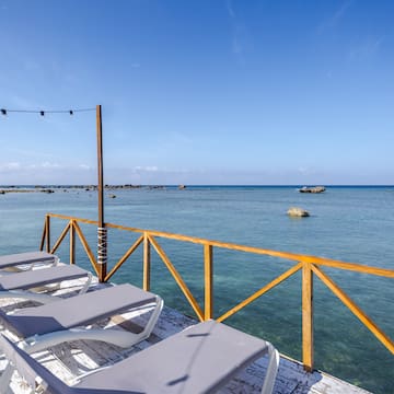 a deck with chairs and a railing overlooking the ocean