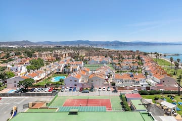 a tennis court and a city with a body of water in the background