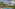 Luxury hotel private pool with tropical garden, palm trees, and thatched gazebo daybed.