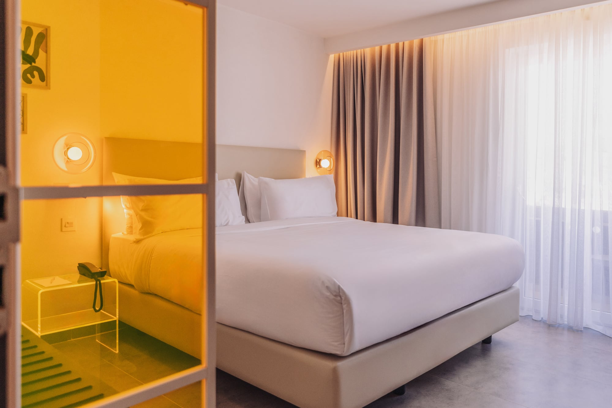 a bed with white sheets and a lamp