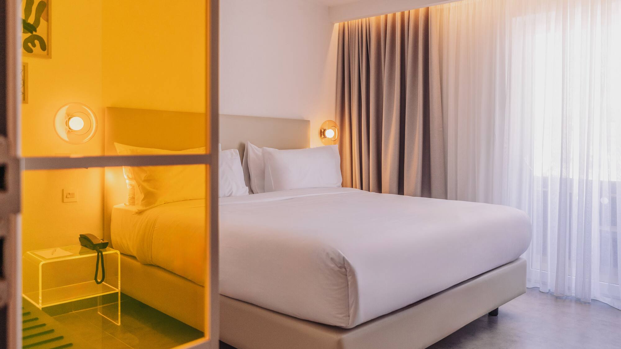 a bed with white sheets and a lamp