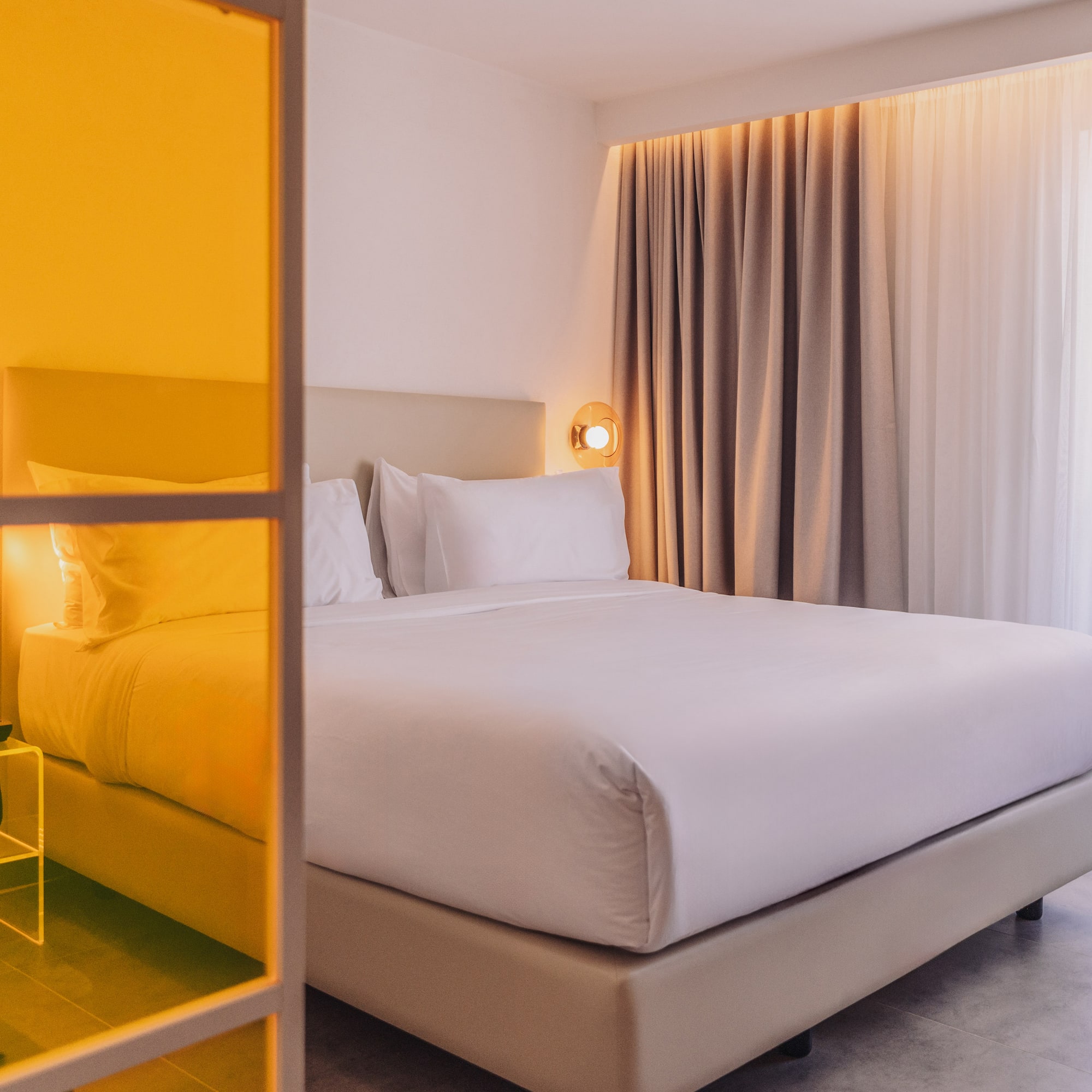 a bed with white sheets and a lamp