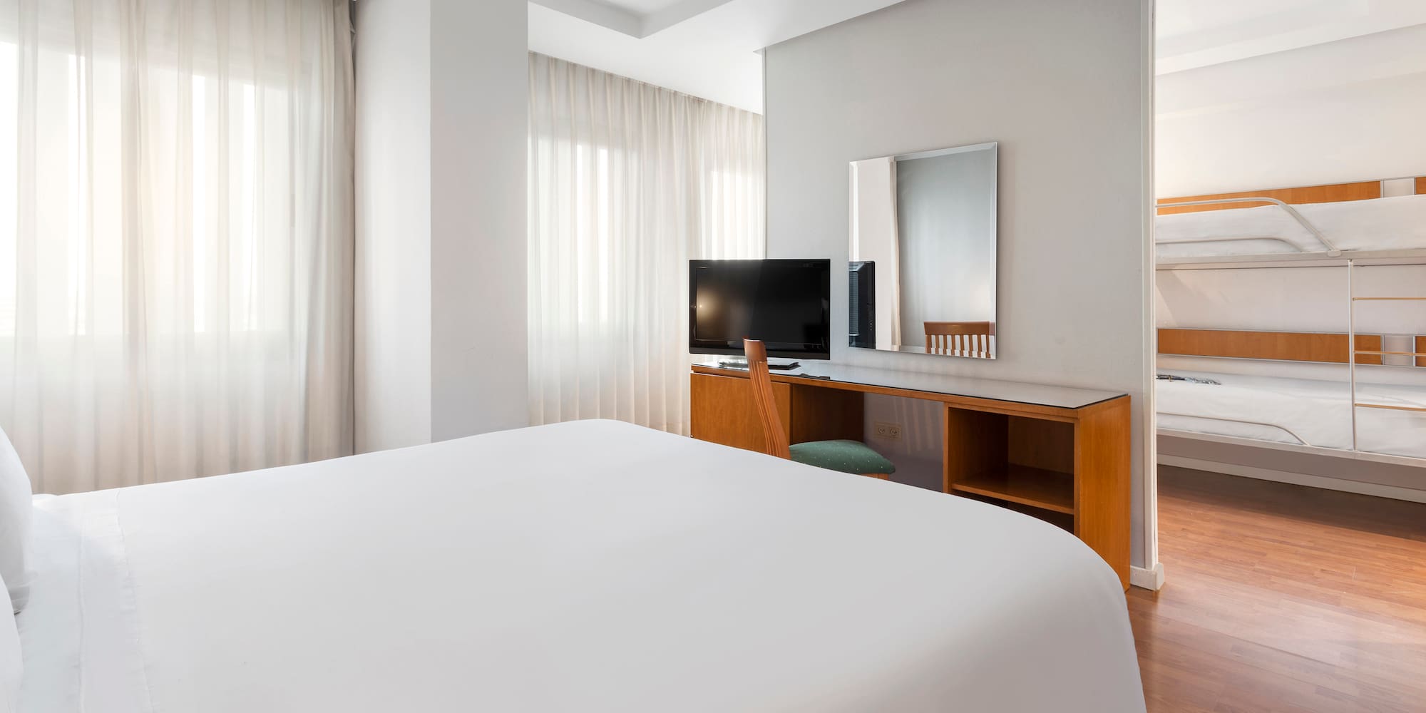 a room with a bed and a desk and a mirror