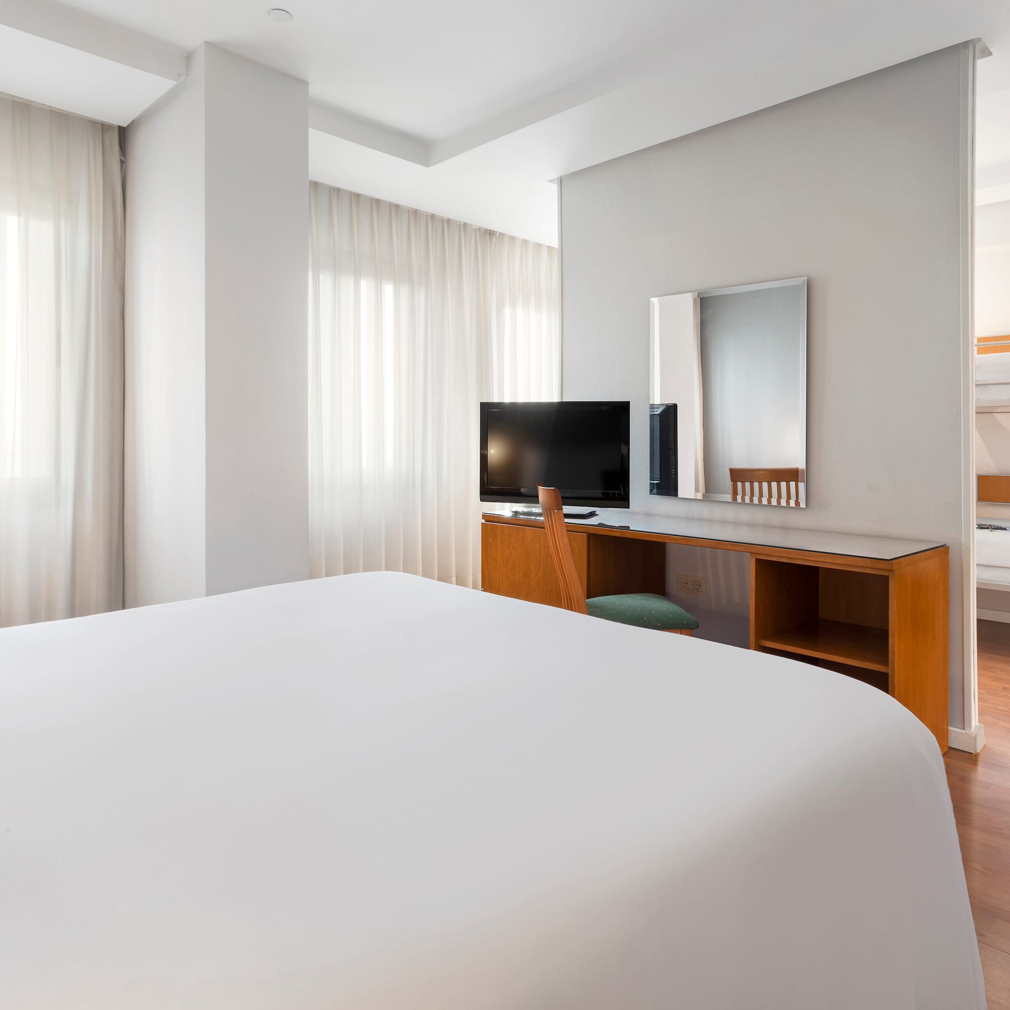 a room with a bed and a desk and a mirror