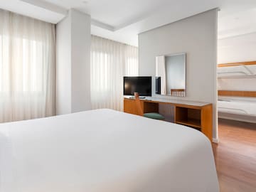 a room with a bed and a desk and a mirror