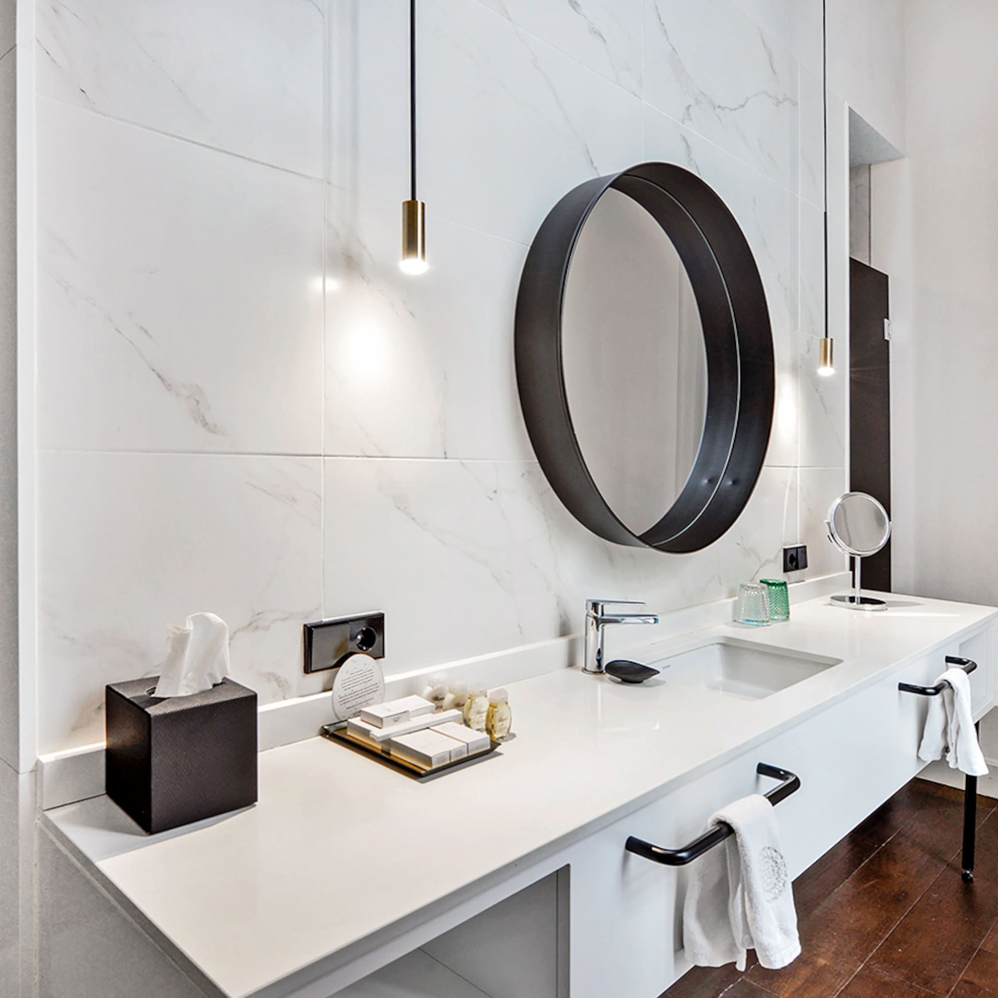 a bathroom with a mirror and a marble wall