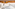 Hand holding black coffee mug with eye icons, emerging from white bed.