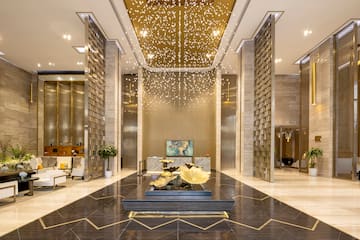 a lobby with a gold ceiling and a gold chandelier
