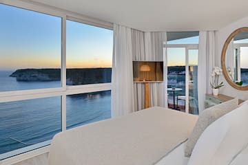 a bedroom with a view of the ocean and a window