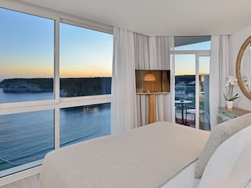 a bedroom with a view of the ocean and a window