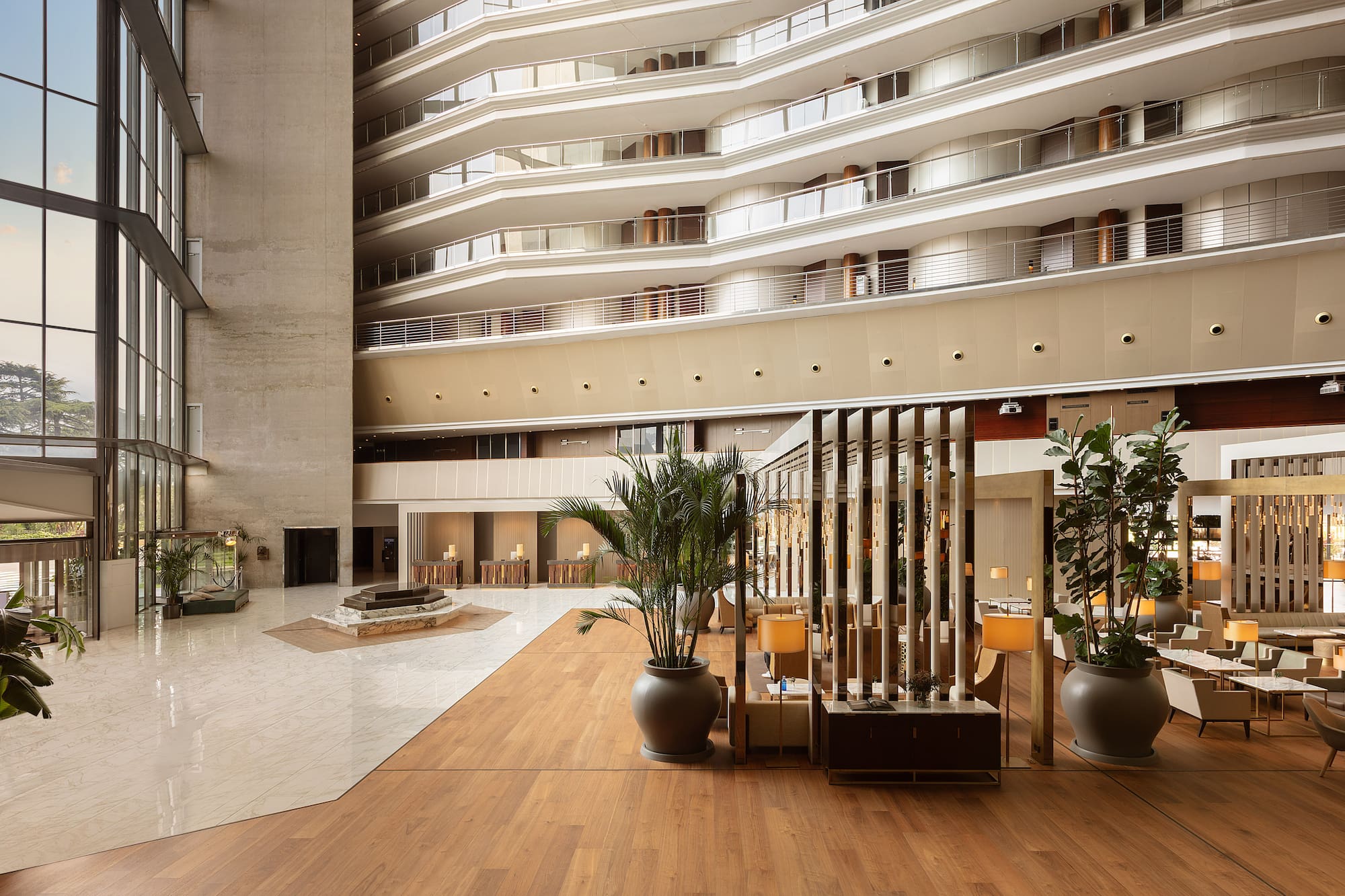 Spacious modern hotel lobby with multi-story atrium, large windows, and seating. - Torre Melina Gran Meliá, บาร์เซโลนา