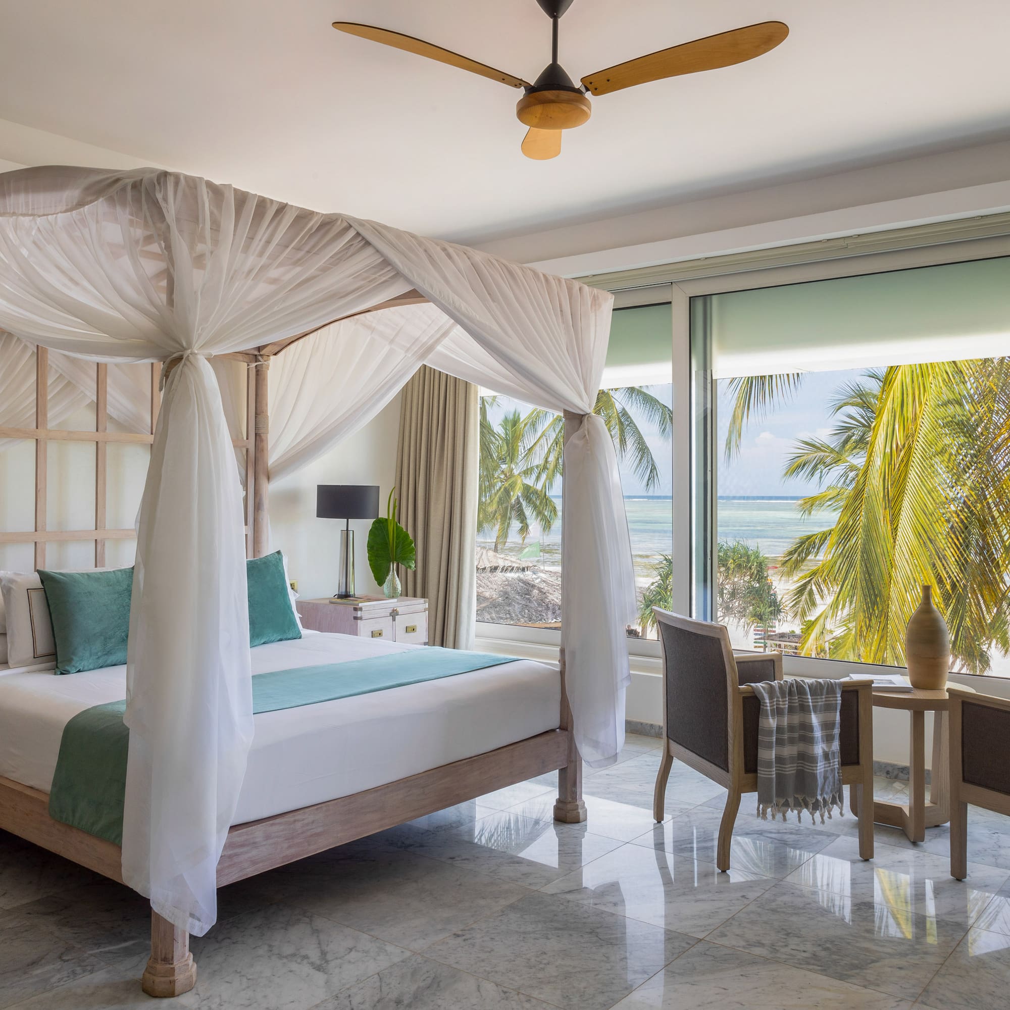 a bedroom with a canopy bed and chairs