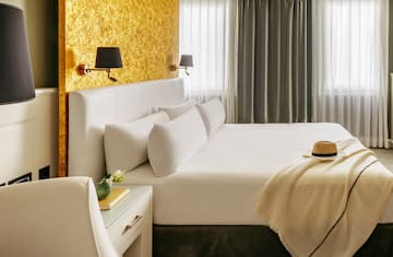 a bed with a hat and a table in front of a window