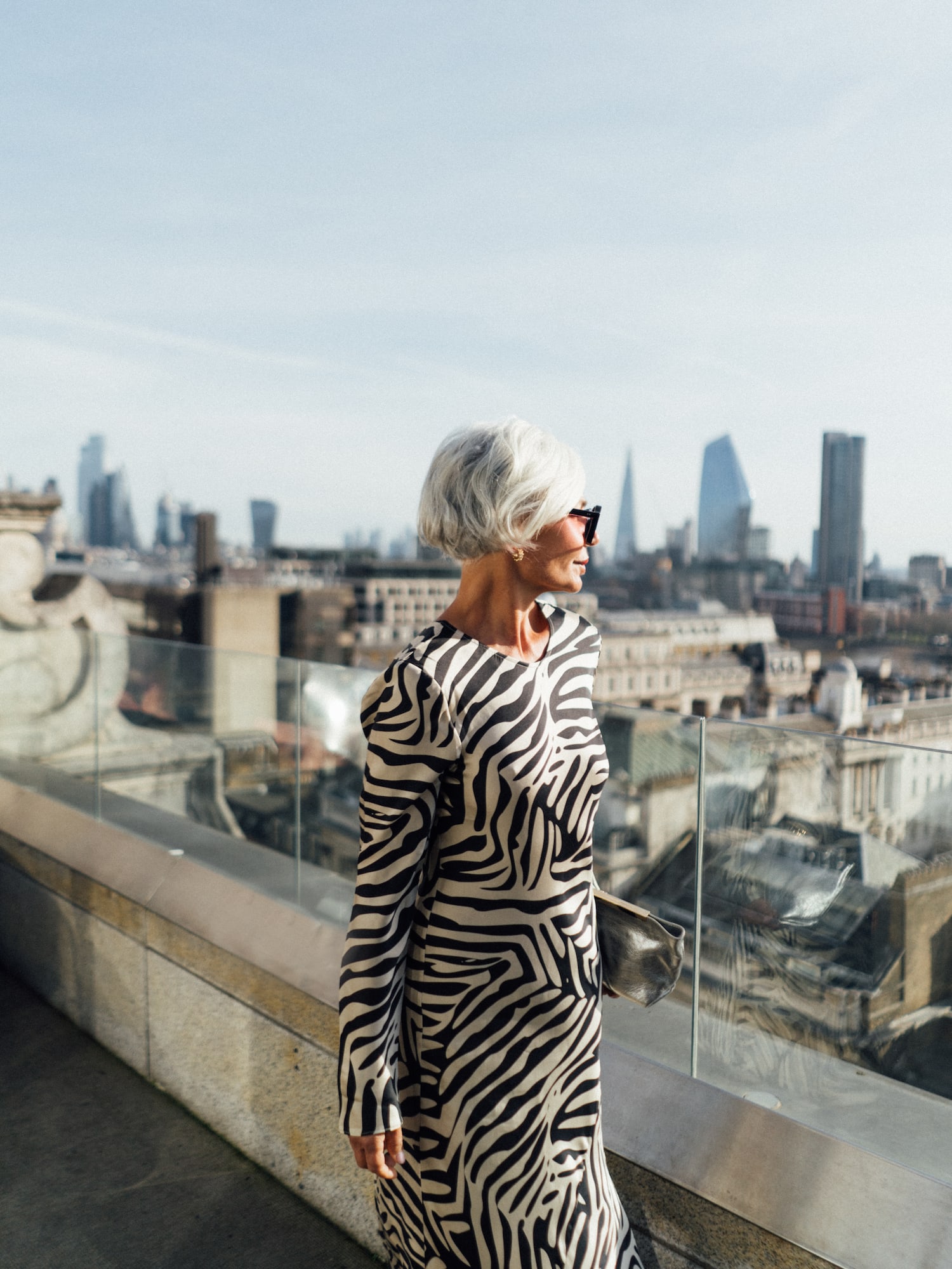 a woman standing on a balcony overlooking a city