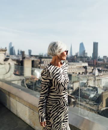 a woman standing on a balcony overlooking a city
