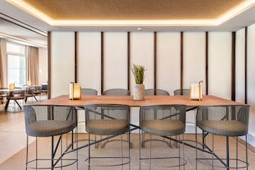 a table with chairs and a vase of flowers