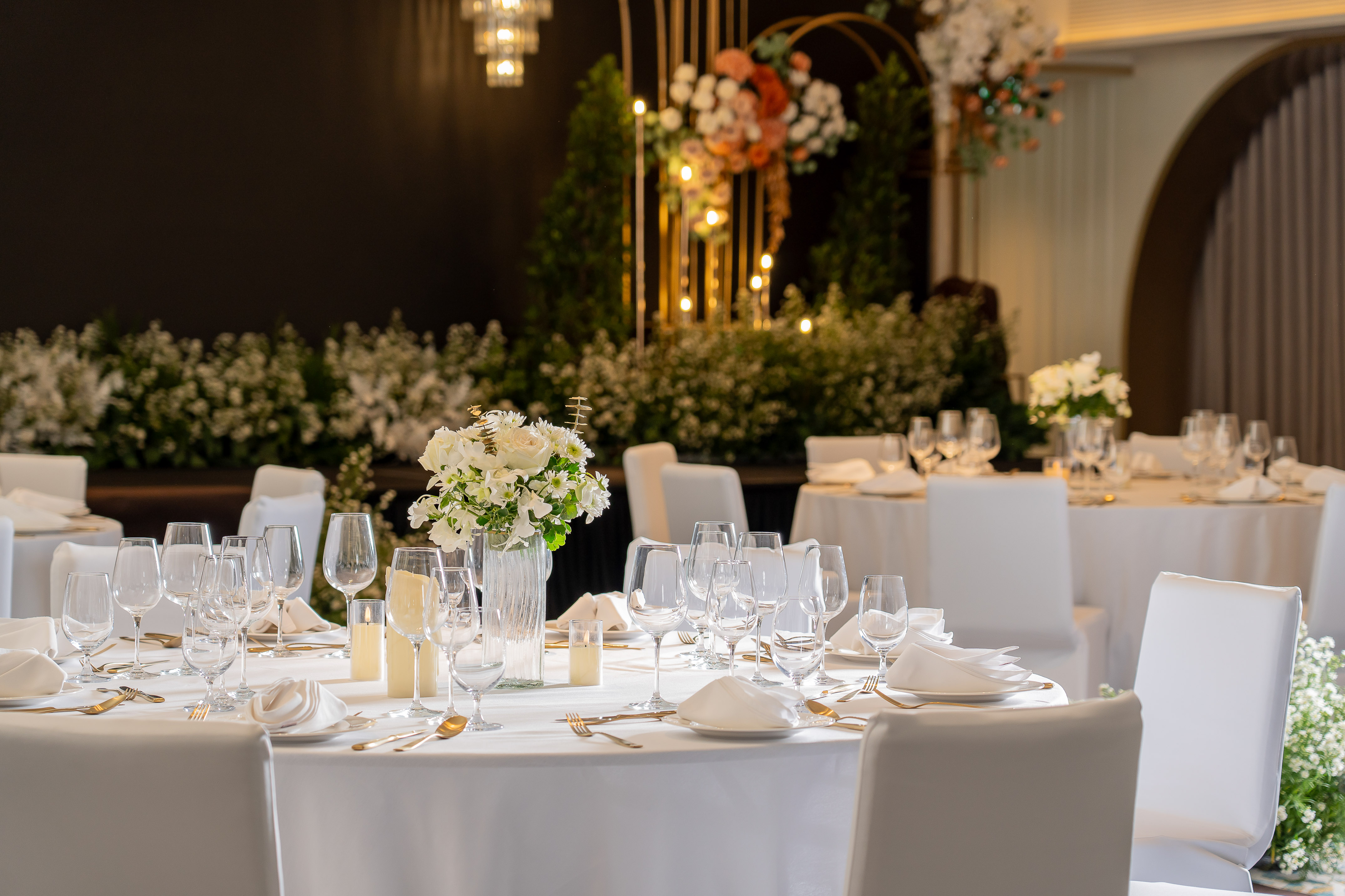 Elegant wedding reception table setting with white floral centerpiece and gold cutlery. - Nuaan - Meliá Pattaya Hotel, Pattaya