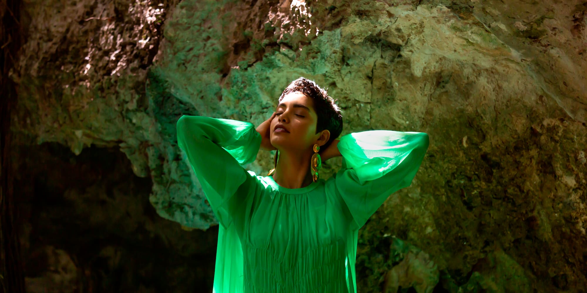 a woman in a green dress with her eyes closed