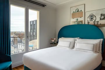 a bed with a blue headboard and white sheets