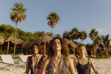 a group of women meditating on a beach