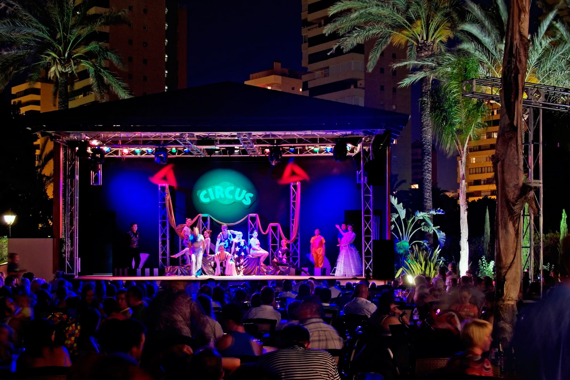 a group of people on a stage with a crowd of people watching