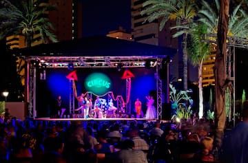 a group of people on a stage with a crowd of people watching