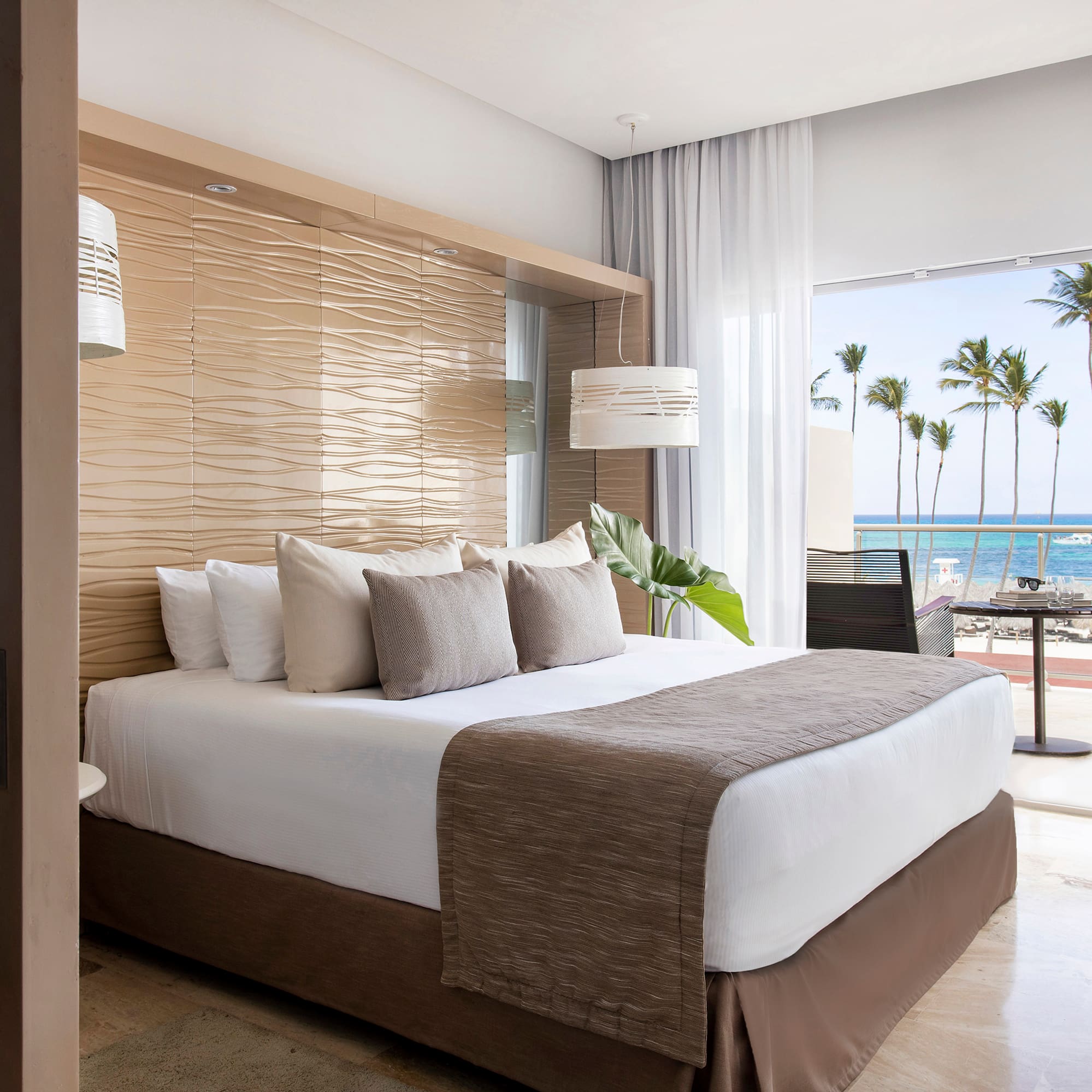 a bed with a large headboard and a large window with palm trees