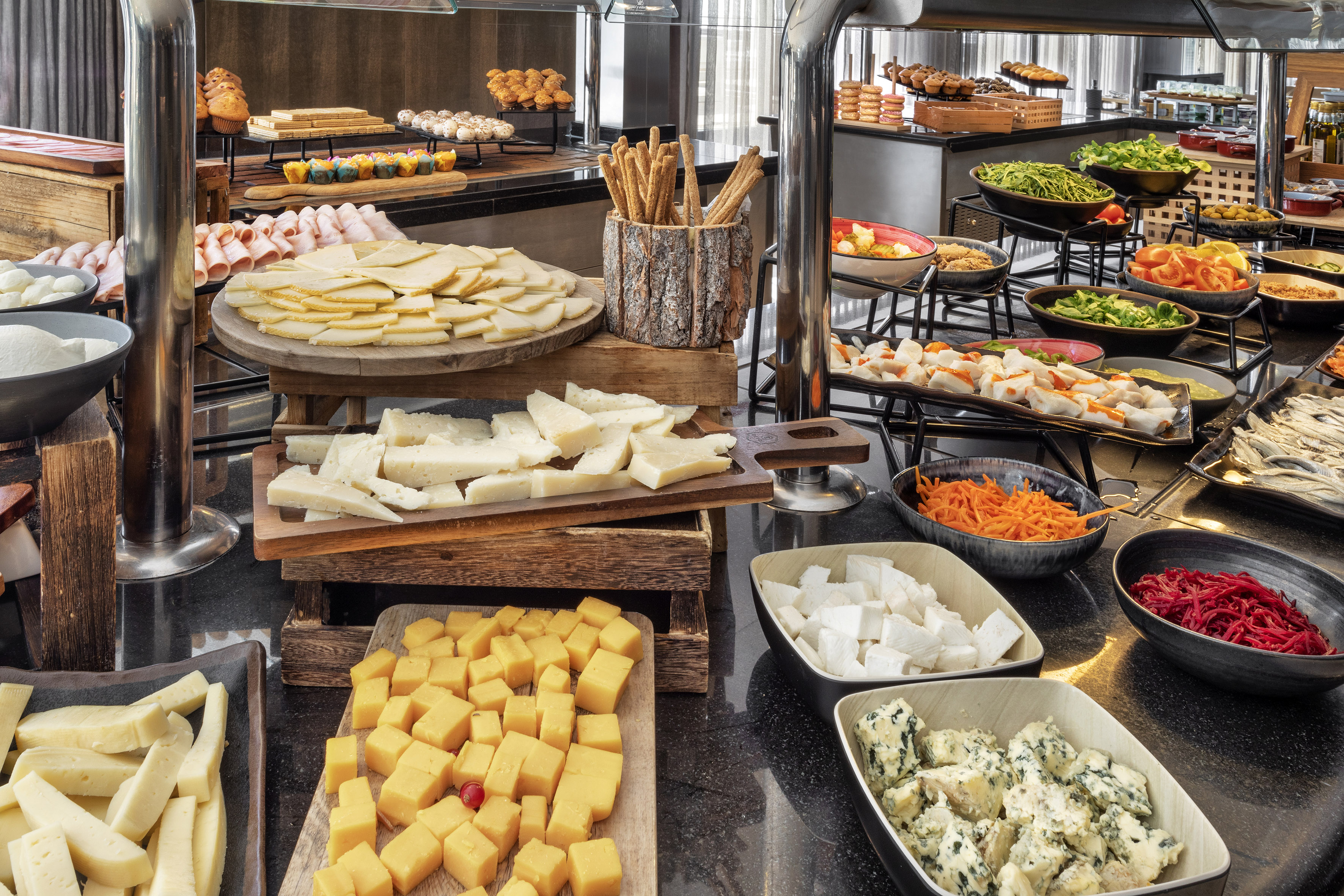 Extensive hotel buffet breakfast with assorted cheeses, charcuterie, and fresh salads.