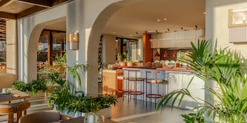 a room with a table and chairs and tables with plants