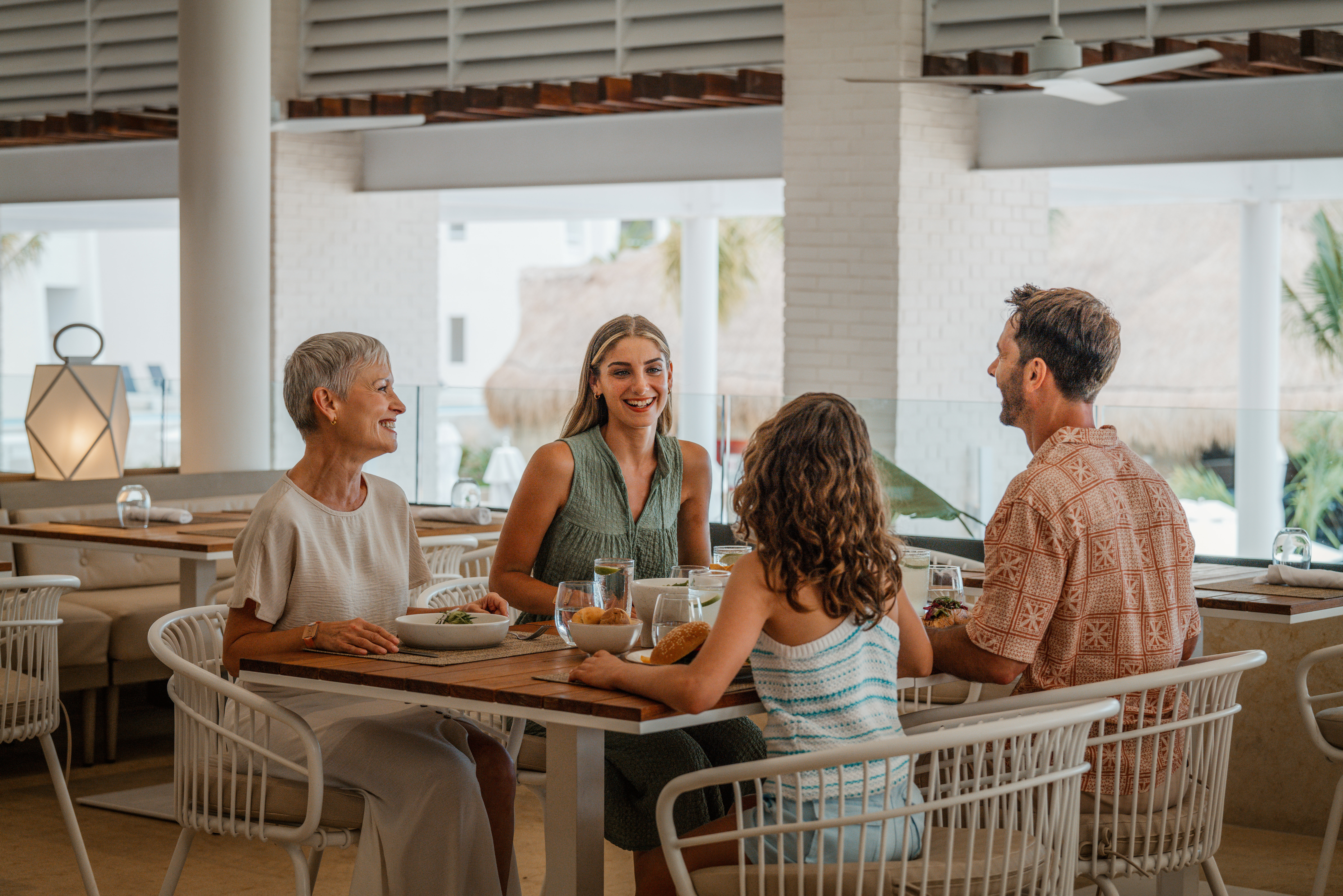 Multi-generational family dining happily at a modern resort restaurant.