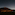 Dark car on road under vast starry night sky, large volcanic mountain in background.