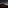 Dark car on road under vast starry night sky, large volcanic mountain in background.