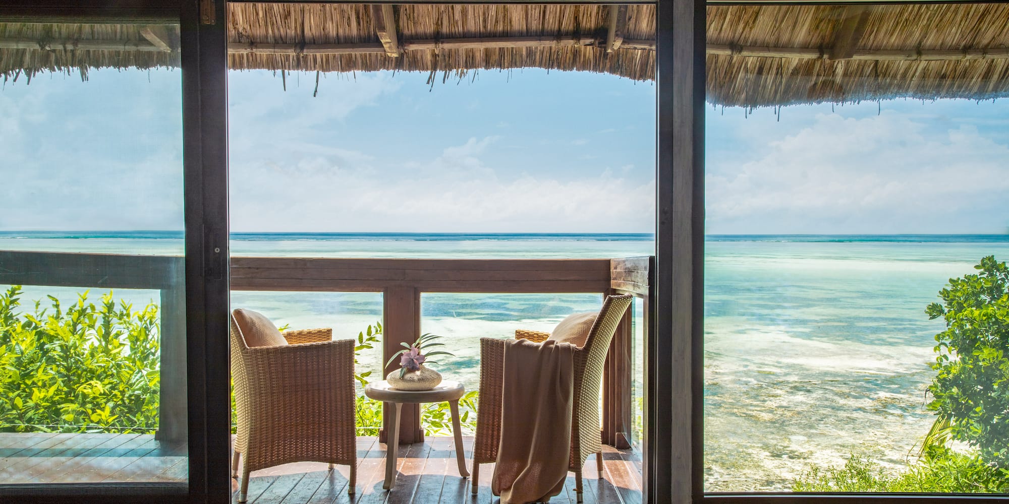 a view of the ocean from a patio door