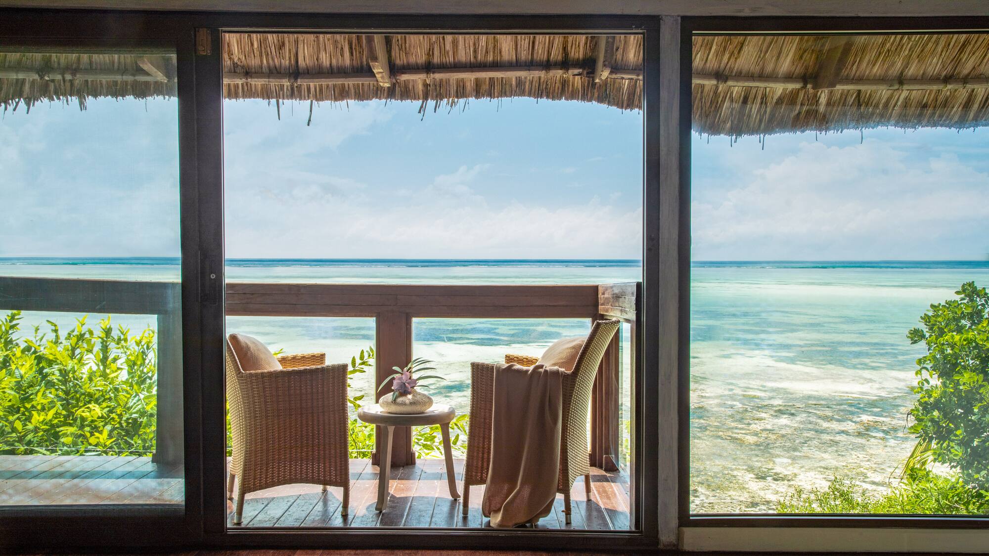 a view of the ocean from a patio door