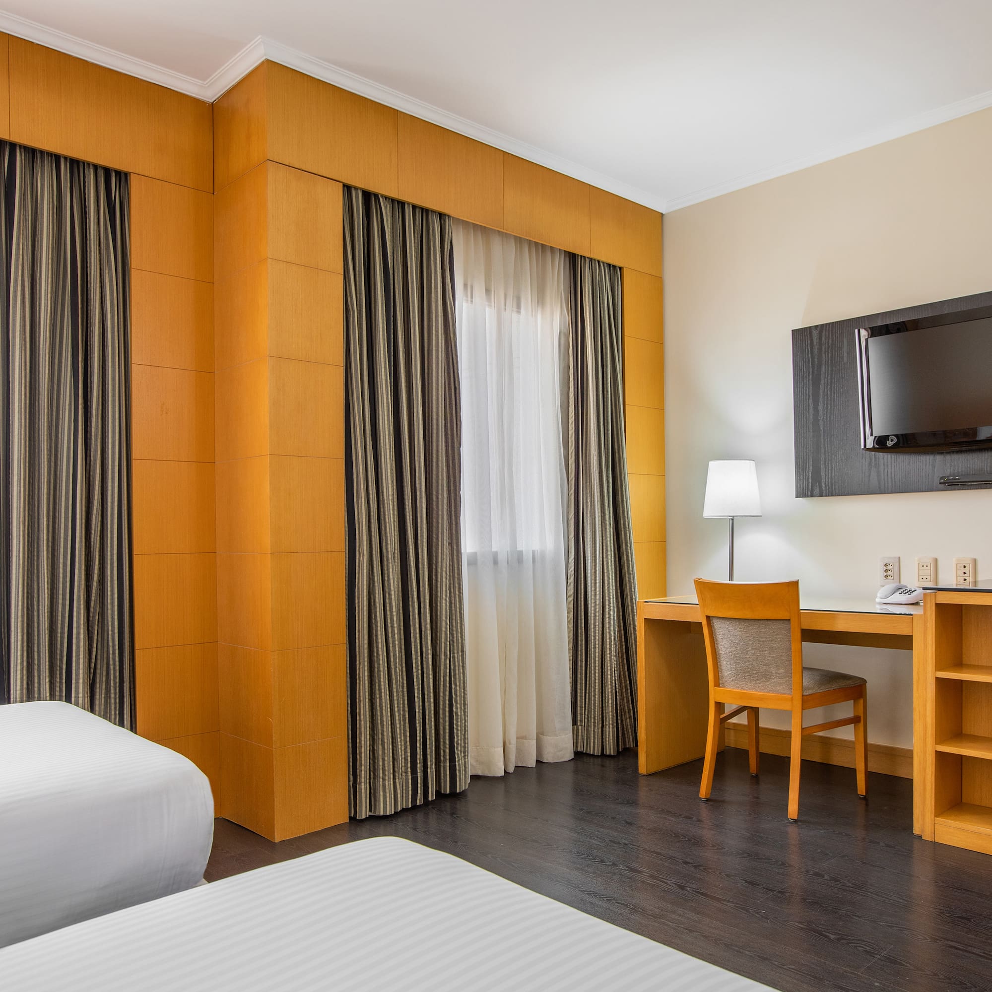 a room with a bed and a desk and a tv