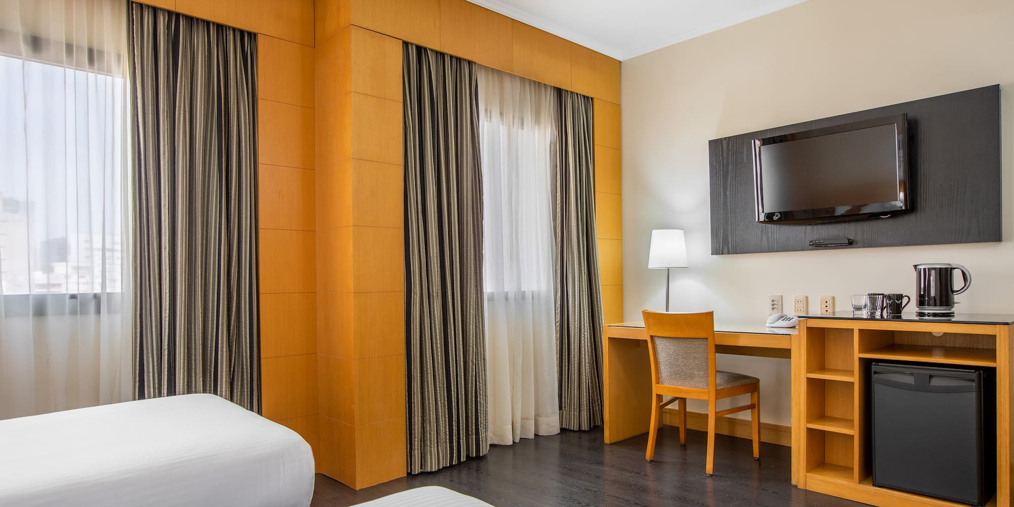 a room with a bed and a desk and a tv