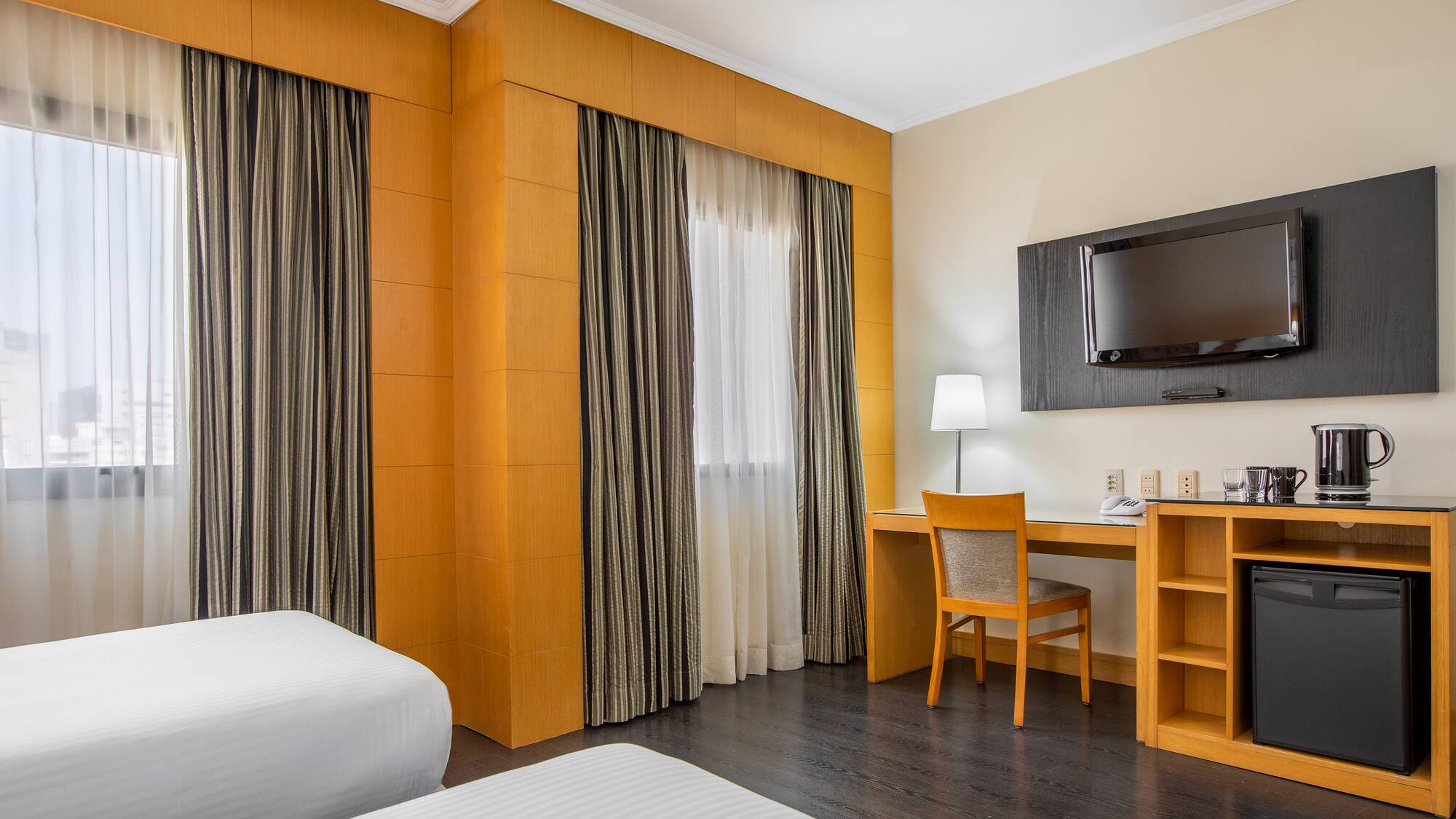 a room with a bed and a desk and a tv