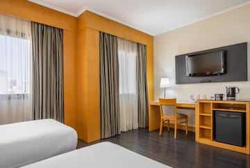 a room with a bed and a desk and a tv