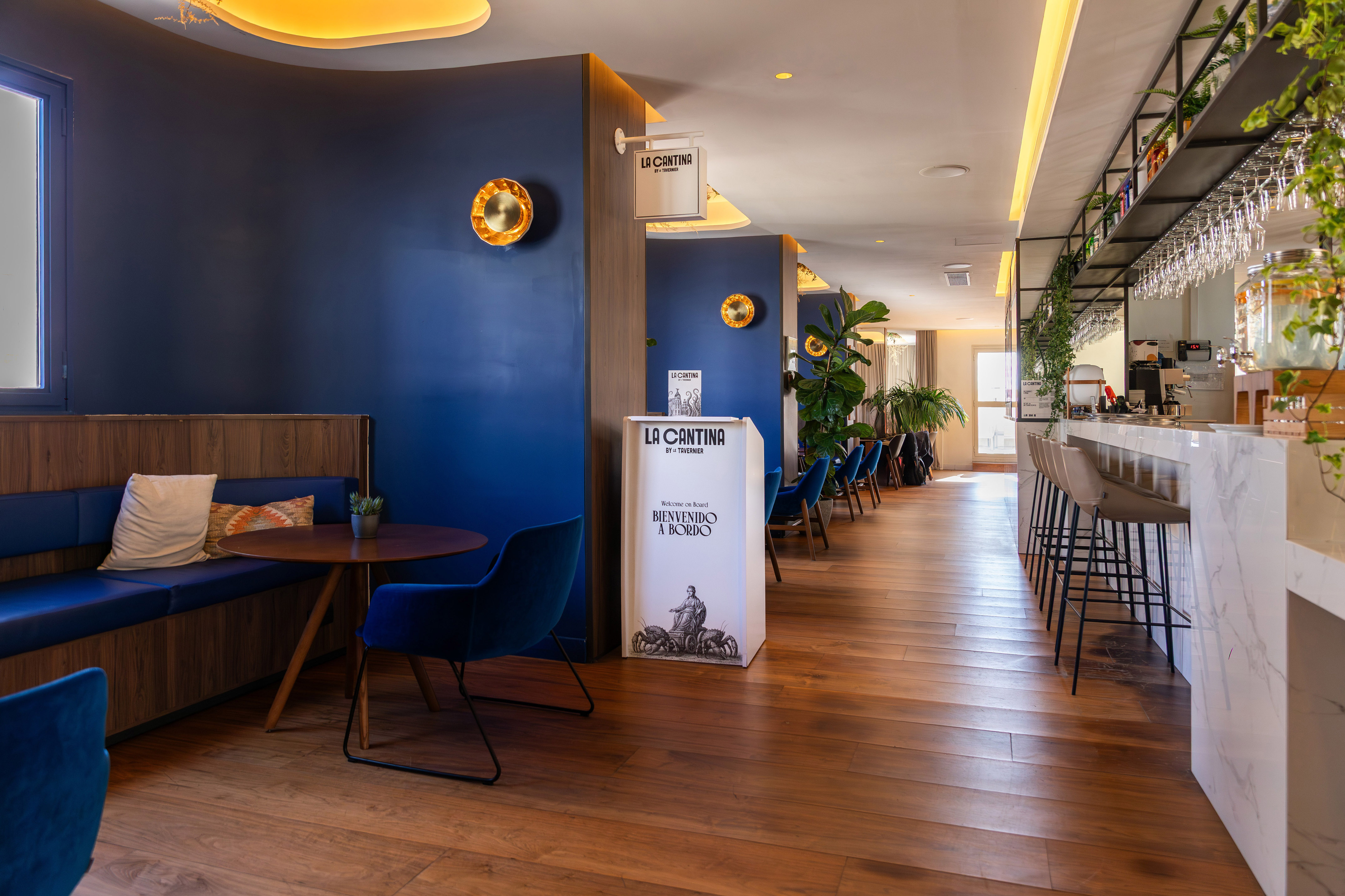 La Cantina restaurant bar with blue walls, wooden floor, and marble counter.