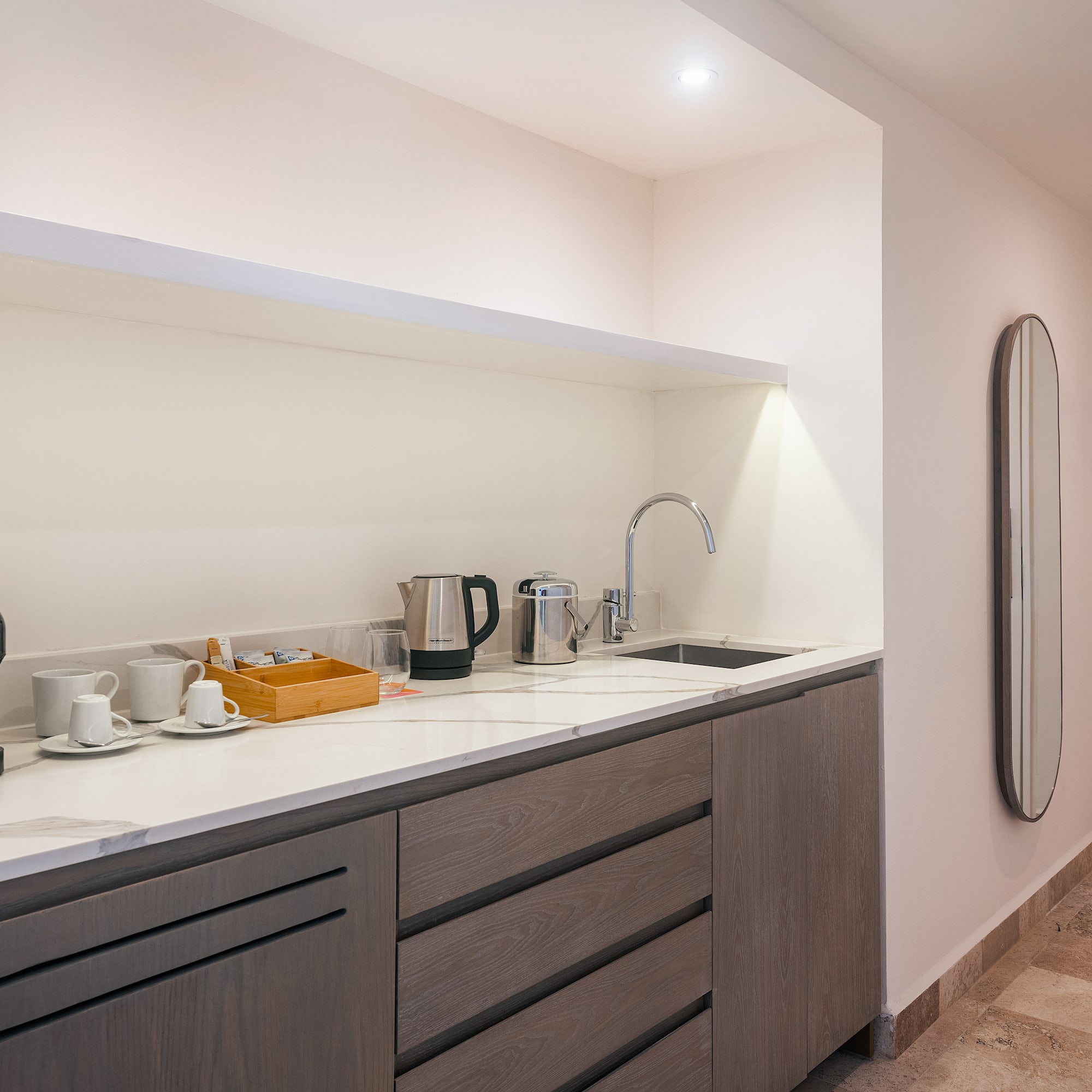 a kitchen with a sink and coffee cups