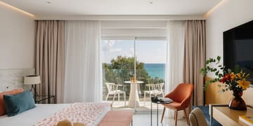 a room with a bed and chairs and a table and chairs