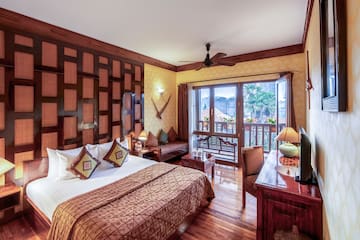 a room with a bed and a desk and a fan