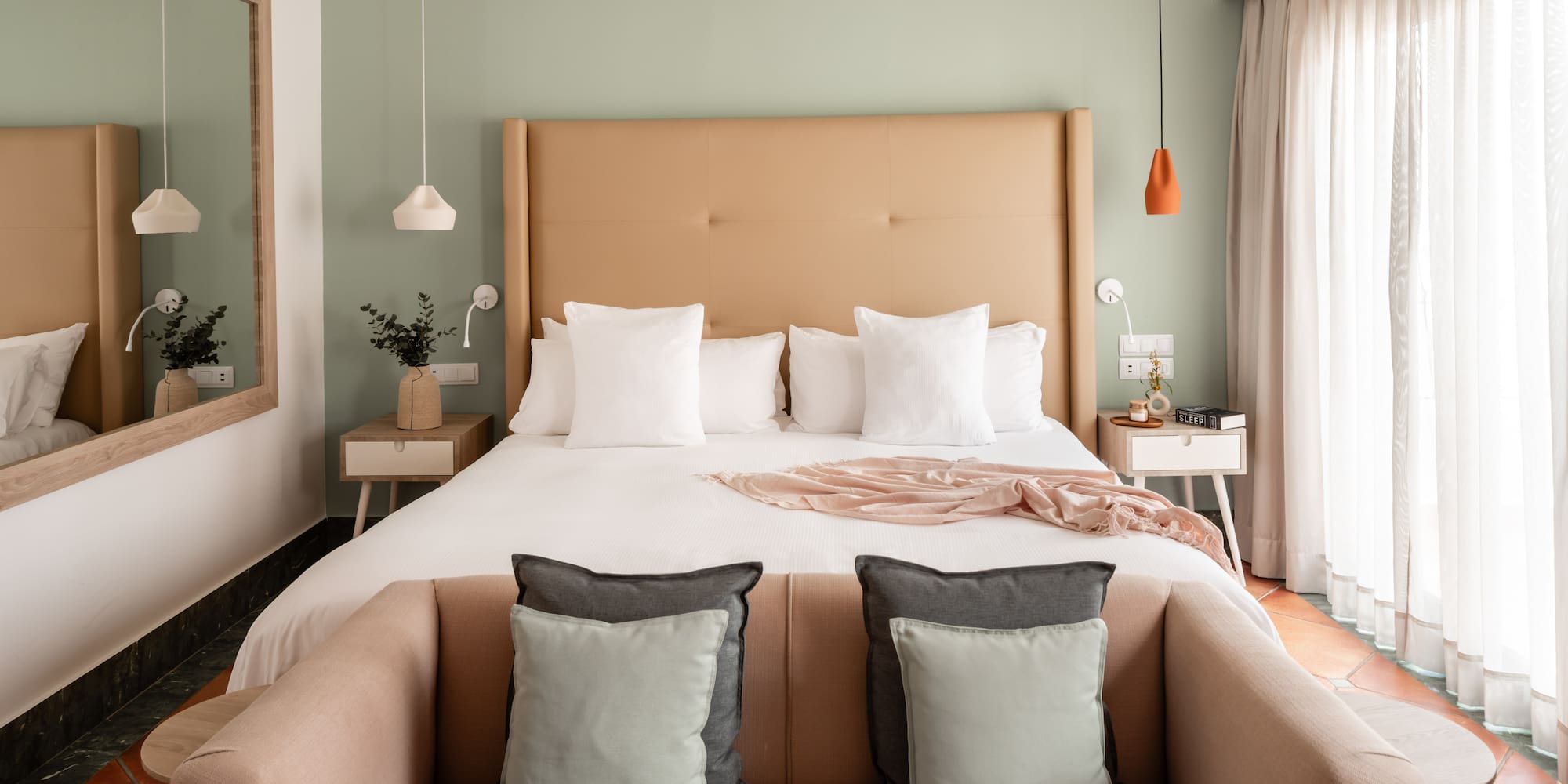 a bed with pillows and a couch in a room