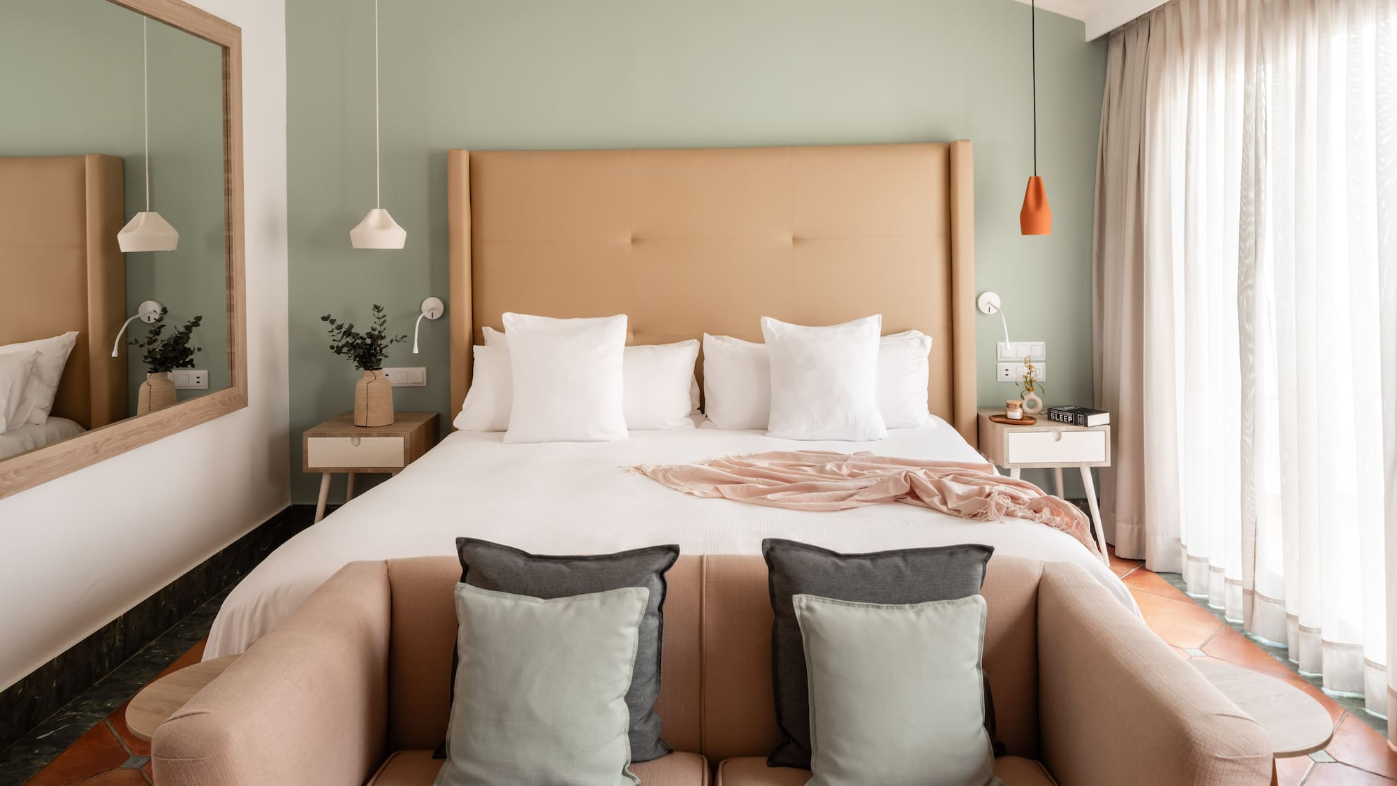 a bed with pillows and a couch in a room