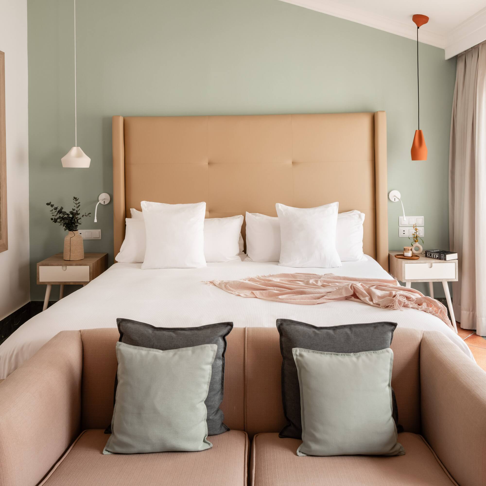 a bed with pillows and a couch in a room